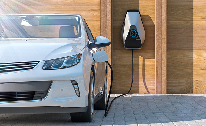 At home EV charging station plugged into vehicle charging port