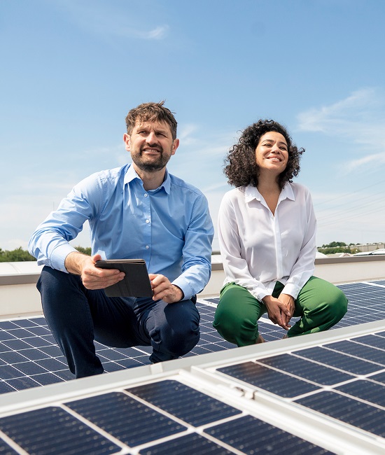 Two people on roof near solar panels