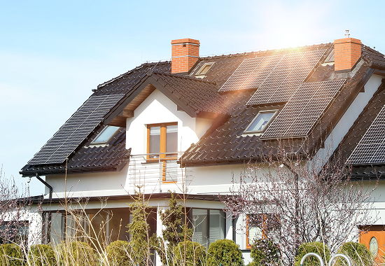 Bright sun powering solar roof panels on a residential home